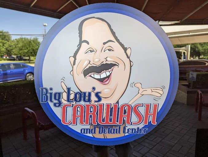 The illuminated round Big Lou's Car Wash and Detail Center sign at the shop