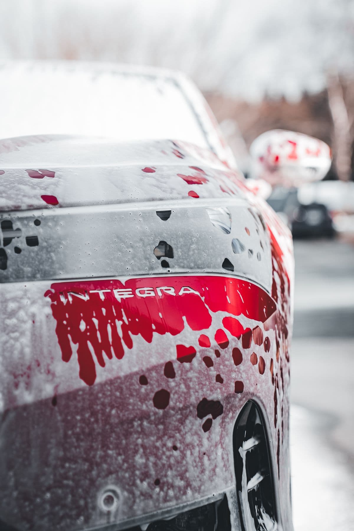A car coated in cleaning foam before being rinsed